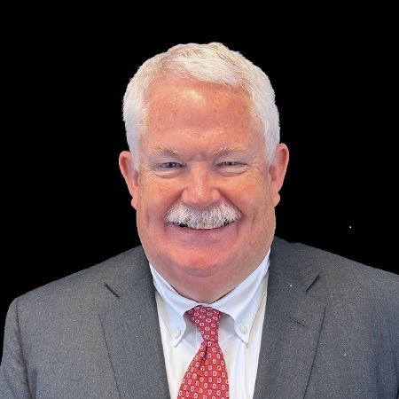 Headshot of a man wearing a grey suit and red tie